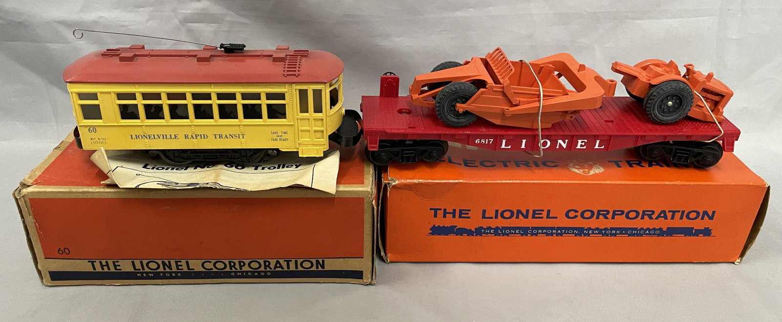 Boxed Lionel 6817 & 60: Includes a 60 Trolley, blue letters, lightly run with instructions, warrantee card & booklet, insert with rough ob; 6817 flat with AC Scraper, broken stack & hitch rod, on an UNRUN flat with respectab