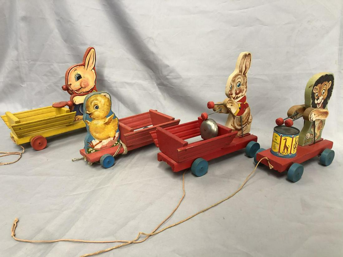 4 Nice Fisher Price Pull Toys: Paper litho on wood. Includes a 480 Leo the Drummer, missing bead; 407 Chick Pulling Cart, string replaced; 508 Bunny on Bell Cart, missing bead; 512 Bunny Pushing Cart with Drum, missing bead. They s