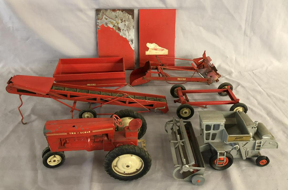 Assorted True-Scale Farm Equipment: Includes a tractor, missing stack; Belt loader; Trailer base with 3 tops; Harvester, tires split, extra trailer top that needs restoring. All show light to moderate playwear.