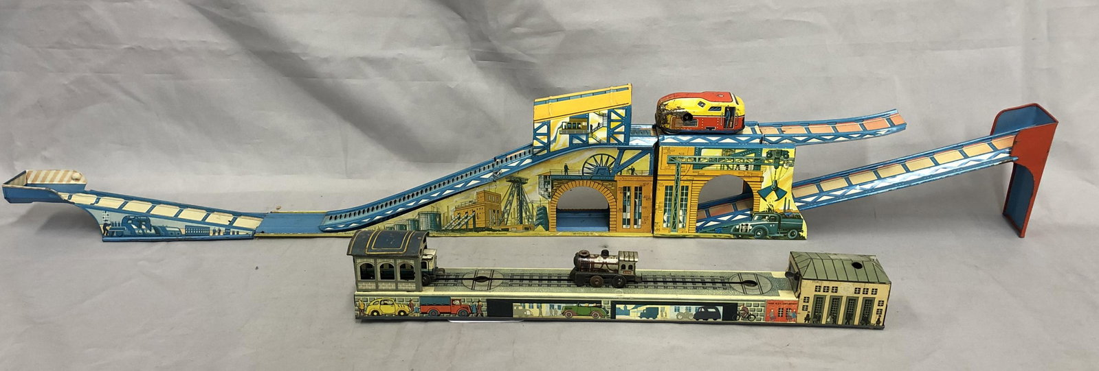 2 German Platform Toys: Includes a Nice Arnold Shunting Train, US Zone Germany. Litho tin, 15” long, mechanism functional with key. Train pushing the pulling coach across platform. Technofix Industrial train with 34” pla