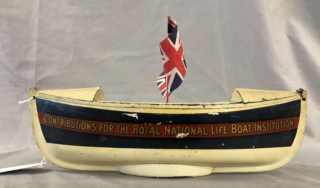 Unusual Life Boat Savings Bank: Painted & decaled pressed steel, 14” long. Reads, “Contributions for the Royal National Life Boat Institution”. It would benefit from a cleaning, no key. It shows light to moderate playwear. Fro