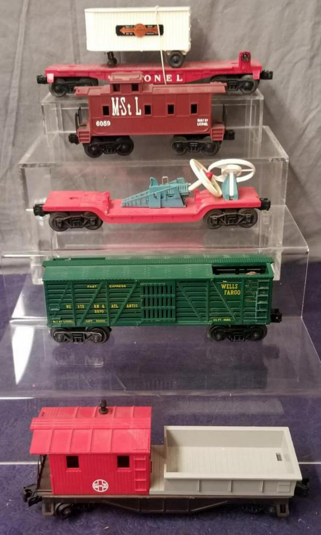 5 Late Lionel Freight Cars, Some NMINT: Includes a 3370 Sherif & Outlaw Car; 3349 Turbo Missile Car, teal blue accessories; 6059 M&StL Caboose, UNRUN; (6130) 1969 version SF Work Caboose, UNRUN; 6810 Flat with Van, UNRUN. Rest Show Light pl