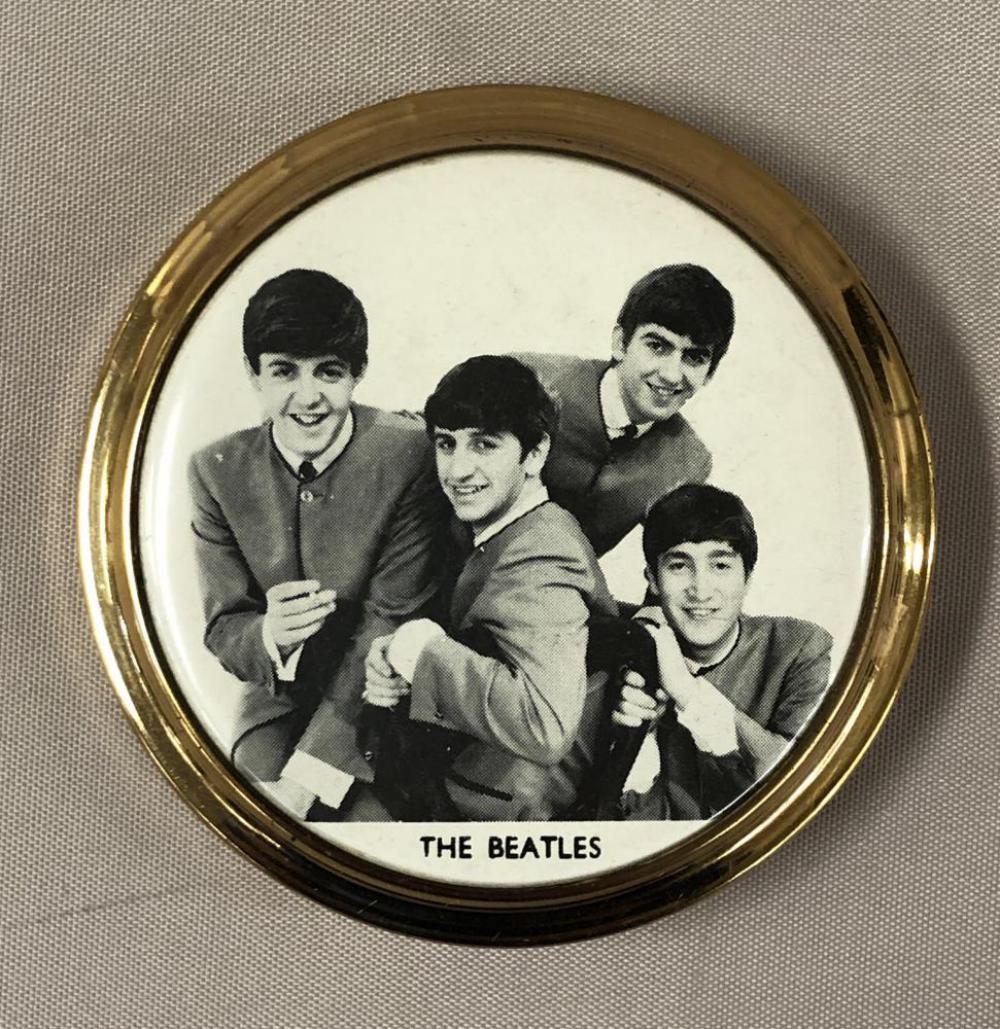 1964, Beatles Makeup Compact & Powder Puff: Offered is a Beatles Makeup Compact & Puff, 1964, Kigu of London, NEMS. Approx. 3" diameter brass compact with black and white celluloid covered group images of the Beatles in their collarless suits. 