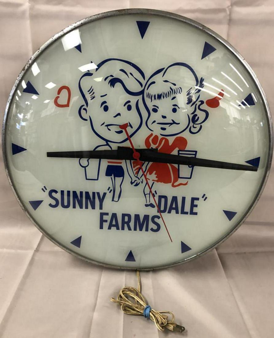 Large Sunny Dale Farms Light-Up Advertising Clock: Rare with reverse painted glass. Approx. 19" diameter. Tested and in working condition. Light outer edge wear with scuffs and scratches. There are a few light paint loss spots in the bottom triangle.