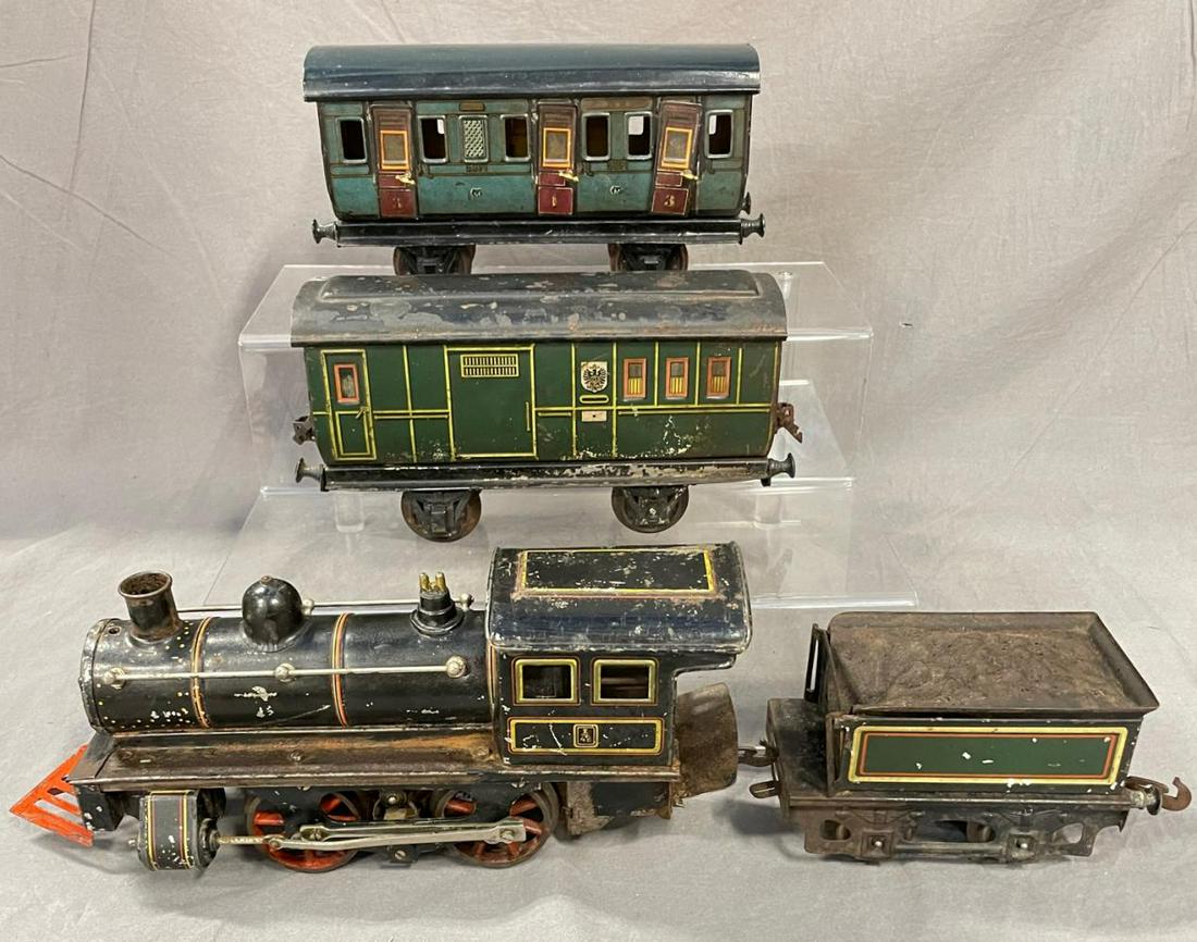 Unusual Carrette 1 Gauge American Steam Passenger: Includes a French style litho 0-4-0 steam loco with electric motor and cow catcher; tender; baggage/postal car; 1st & 2nd class compartment coach. All show moderate playwear.