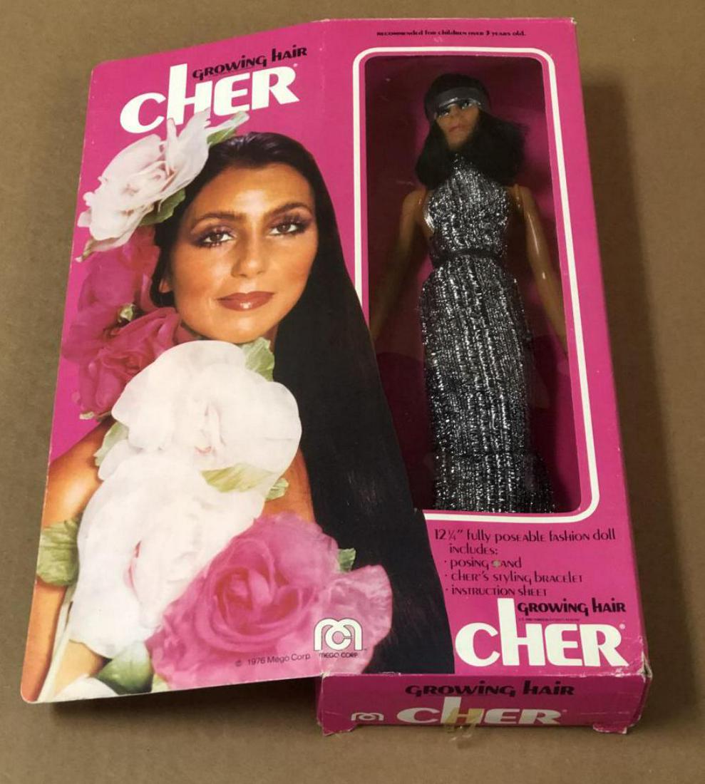 1976 Boxed Growing Hair Cher Doll, Mego: Boxed, Growing Hair Cher Doll by Mego, 1976. Approx. 12-1/4" poseable doll. Complete with styling bracelet and instruction sheet. Opened box, doll is still tied to the cardboard insert. Box shows edge