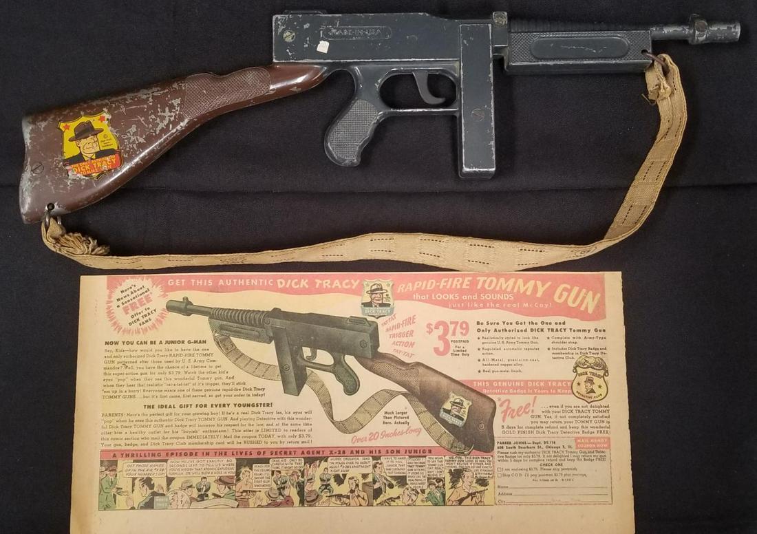 Dick Tracy Rapid Fire Tommy Gun With Canvas Strap: (Parker John, 1947). Approx. 20-1/2" in length, this scarce, pressed-steel toy gun features a white canvas strap and a full-color Tracy decal logo on its stock. Working condition, however when the tri