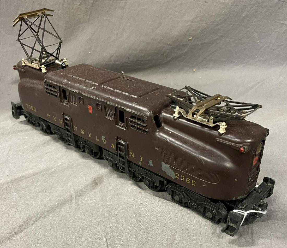 Lionel 2360 PRR GG1 Electric: 1956. It is tuscan and had 5-stripes that no longer exist, but a shadow of them. It is dual motor with horn and shows moderate play wear.