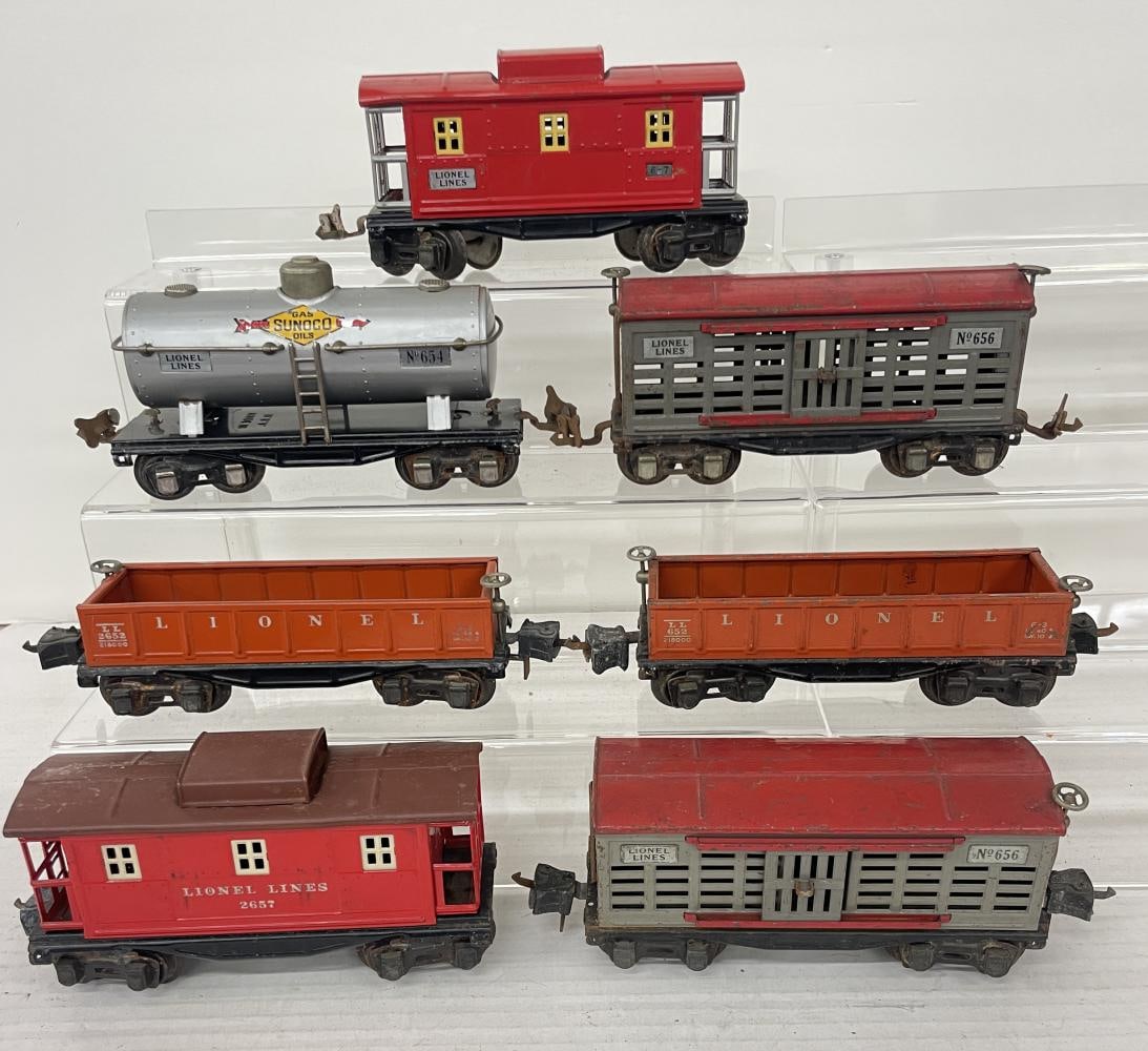 7 Lionel Freight Cars: Includes late 2652 Gondola; 2656 Stock Car; 2657 Caboose; 657 Caboose; 654 Sunoco Tank; 656 Stock Car; late 652 gondola. All show moderate play wear.
