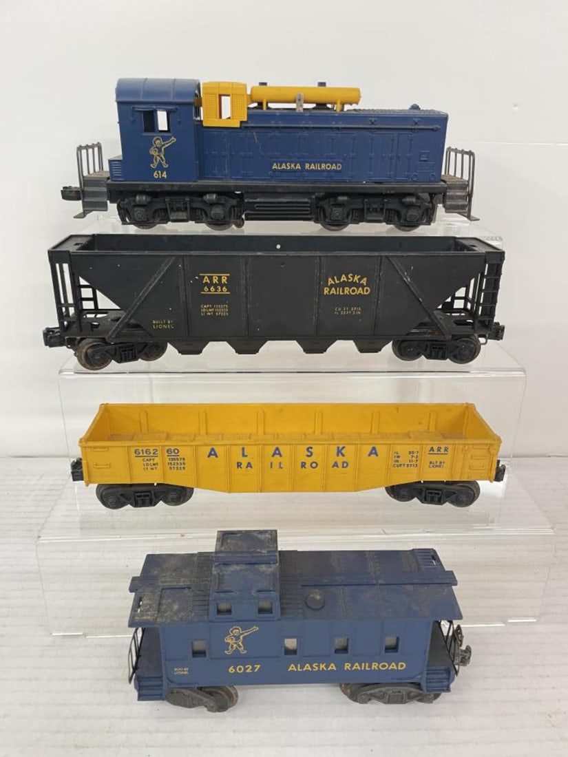 4pc Lionel Alaska Train: Includes a 614 Alaska NW2 Diesel, closed hairline screw crack, original brake unit; 6162-60 Alaska Gondola, no canisters; 6636 Alaska Quad-hopper; 6027 Alaska Caboose with 2457 chassis. All would bene