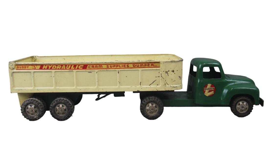1950s Buddy L Farm Supplies Dumper: Painted pressed steel with rubber tires, 23 inches long. Dump works, but quickly and has nice decals. It shows light to moderate play wear. Would benefit from a cleaning.