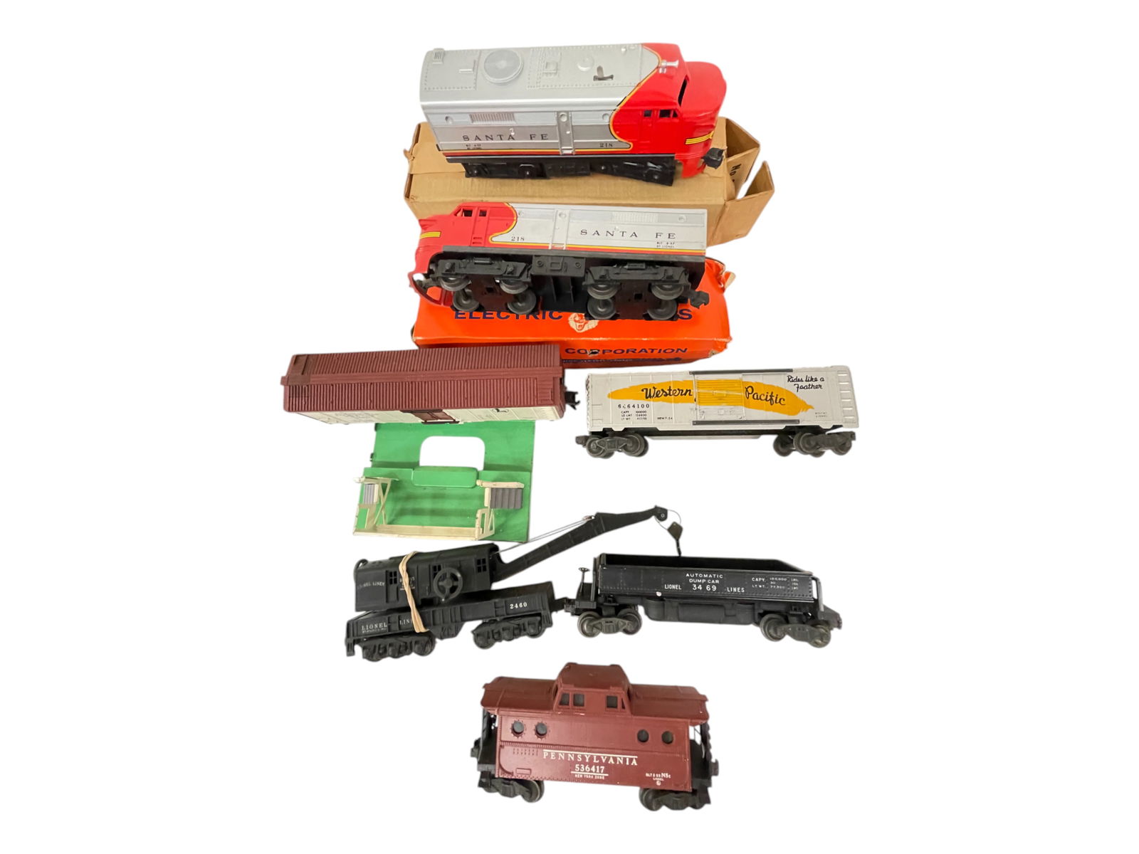 Lionel Postwar Trains Group: Includes a 218 SF Alco AA Diesels, intact cowls, rough boxes; 3662 Milk Car & Platform, cans inside, missing platform top; 3469 Coal Dump; 6464-100 WP Boxcar; 2460 Crane, missing cab screws, posts goo