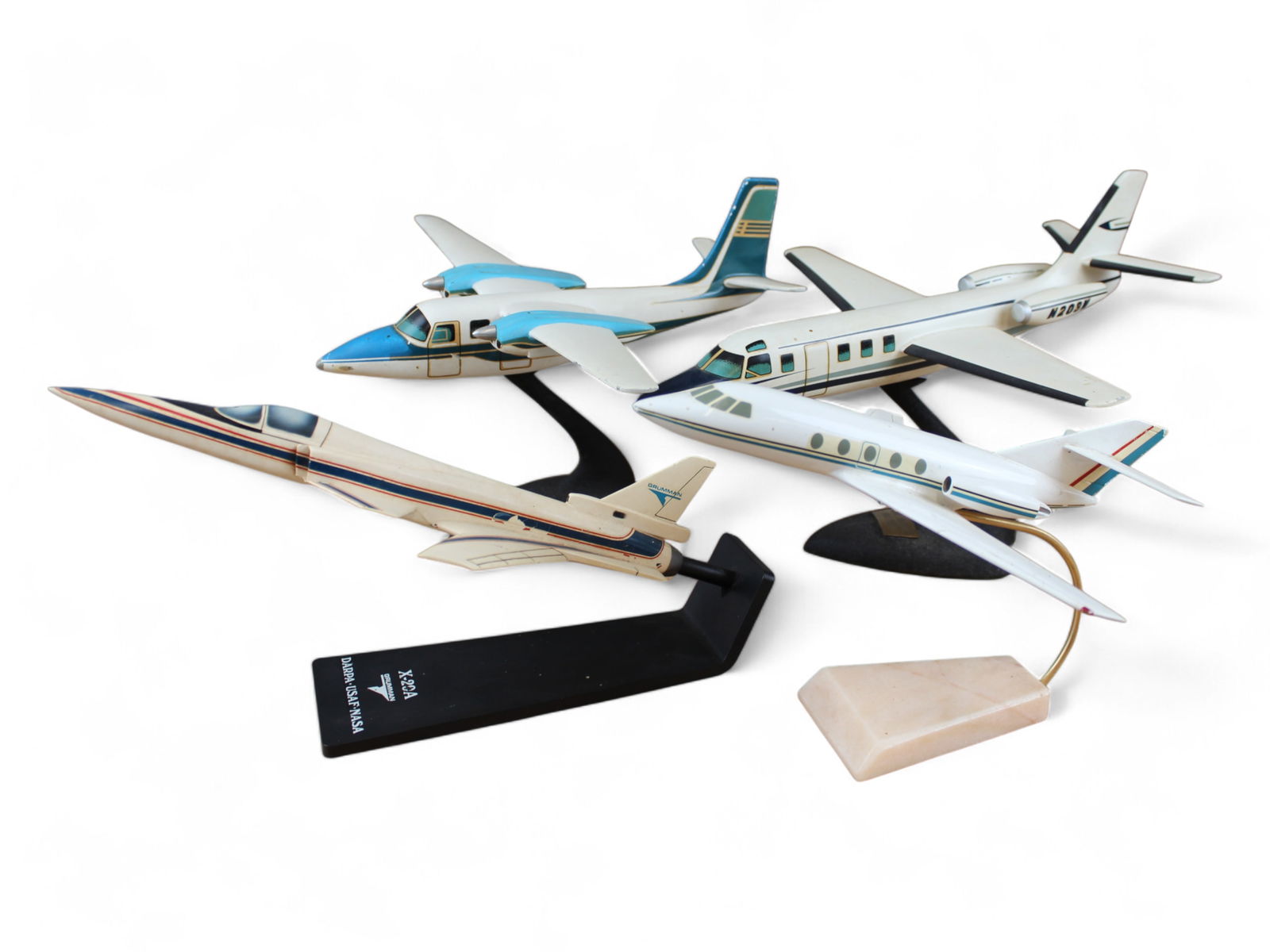 (4) Desk Model Airplanes: 4 Desk Model Airplanes including Grumman X-20A, Israel Aircraft Industries, and 2 unmarked. Approx. 10''-14'' long.