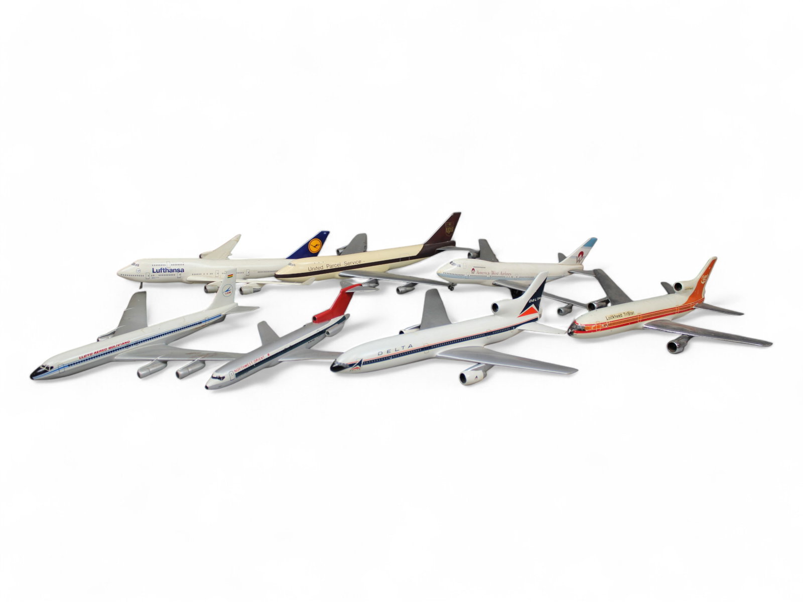 (7) Desk Model Airplanes: 7 Desk Model Airplanes without bases including Northwest Orient, Lockheed, America West, UPS, Delta, Lloyd Aereo Boliviano, and Lufthansa. Approx. 9'-11'' long.
