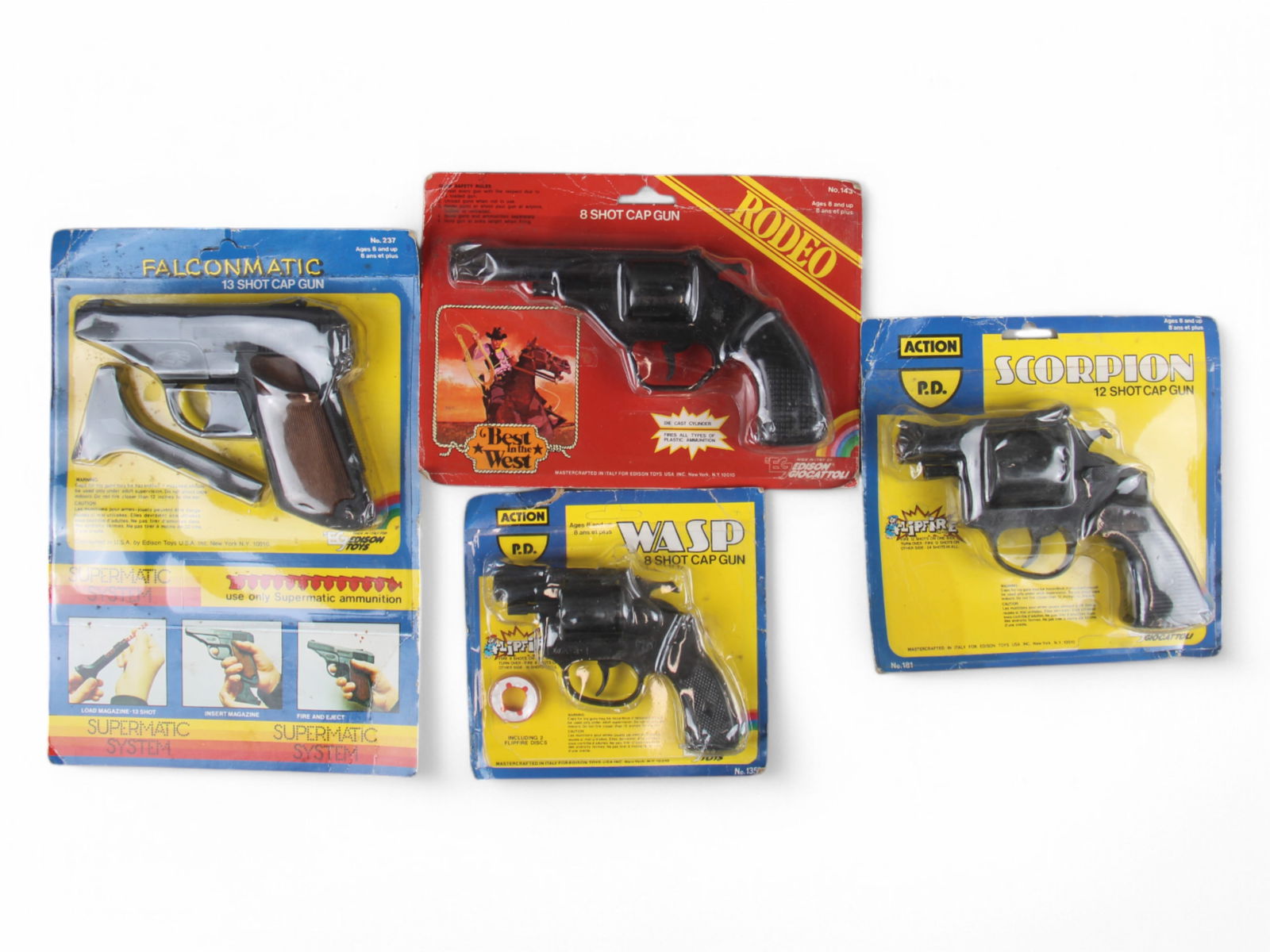 Lot of 4 Mint on Card Cap Guns: Edison Giocattoli. Includes Rodeo 8 shot cap gun, Wasp 8 shot cap gun, Scorpion 12 shot cap gun, and Falcon Matic 13 shot cap gun. Packaging to each is rough with tears, creases, crushed spots, etc. C