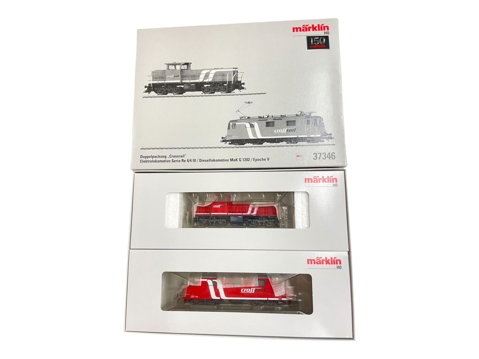 Marklin Digital HO 37346 CrossRail: HO Gauge. Nice 150 year anniversary set with Serie Re 4/4 III Electric and MaK G 1202 diesel. They are equipped with mfx control and appear new in set box.