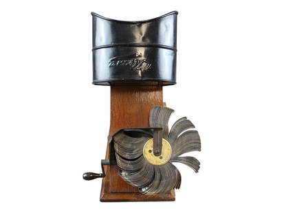 Circa 1910, Kinora London Viewer with Picture Reel: Kinora Ltd., London, Cinematographic Viewer on shaped wood base, metal hood and picture reel numbered 243. Reel depicts figures skiing and sledding. Working condition. These viewers were based on the