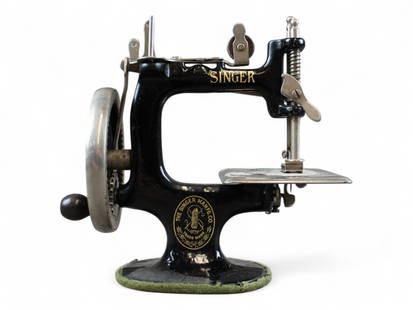 Miniature Singer Sewing Machine: Approx. 7" x 6-1/2". Crank turns and needle moves. Shows overall wear throughout.