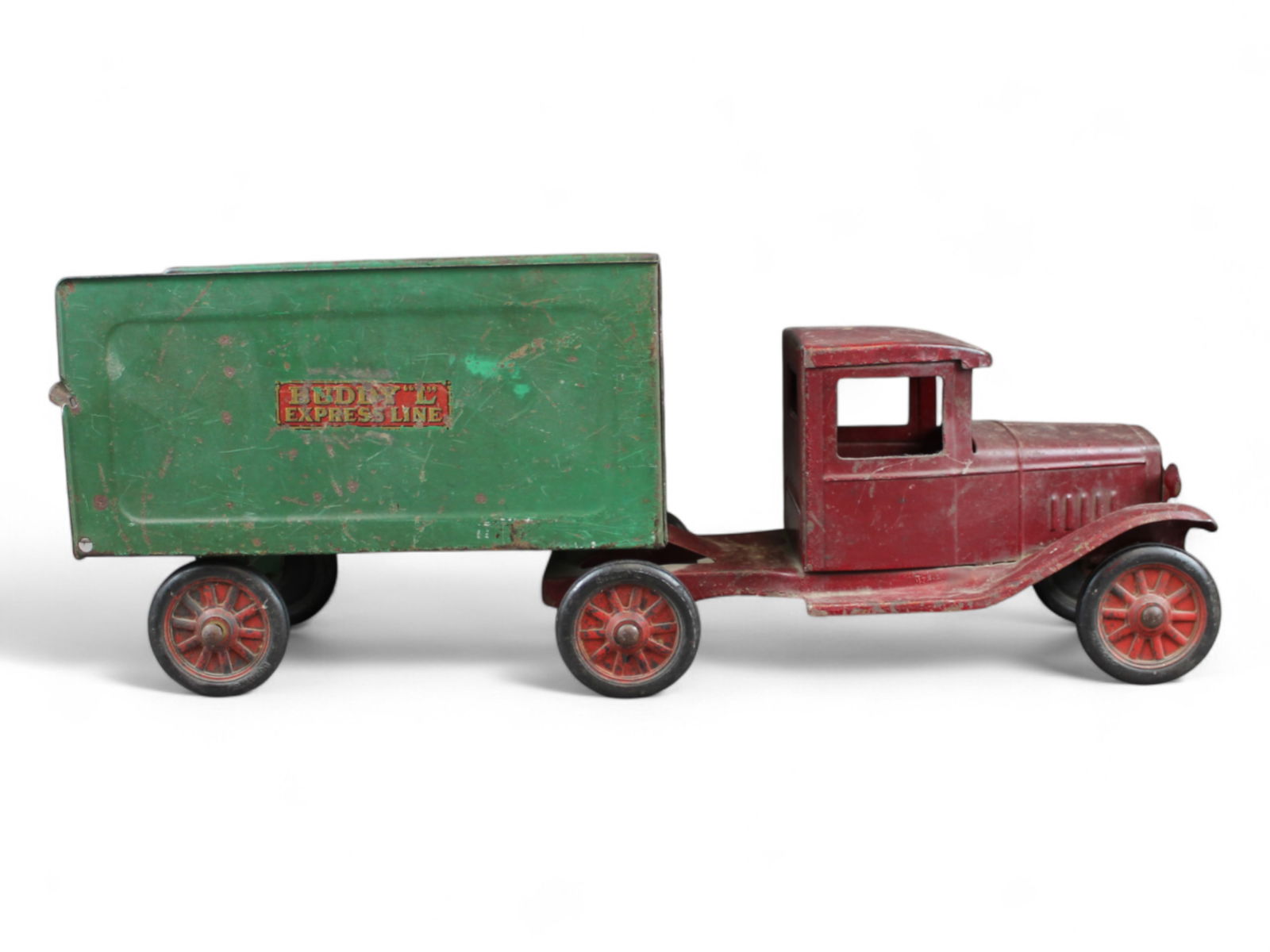 Buddy L Express Truck: Circa 1934. Painted pressed steel with BRT over cast hubs with spoke details. The tractor has been over-painted, trailer has 85% decals and retains its rear ramp, missing top. It shows moderate to hea