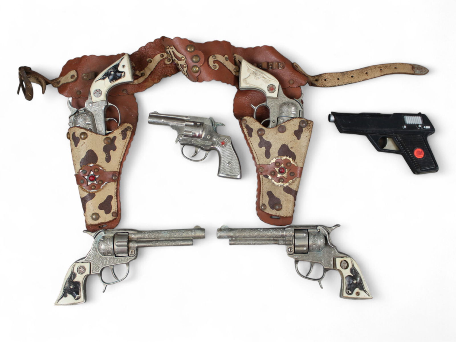 Assorted Cap Guns: Includes a Hubley Texan Jr Double Holster set; 2 Hubley Texan Guns; Hubley Trooper; 1965 Ideal Man From Uncle. All work & show play wear, some would benefit from lubrication.