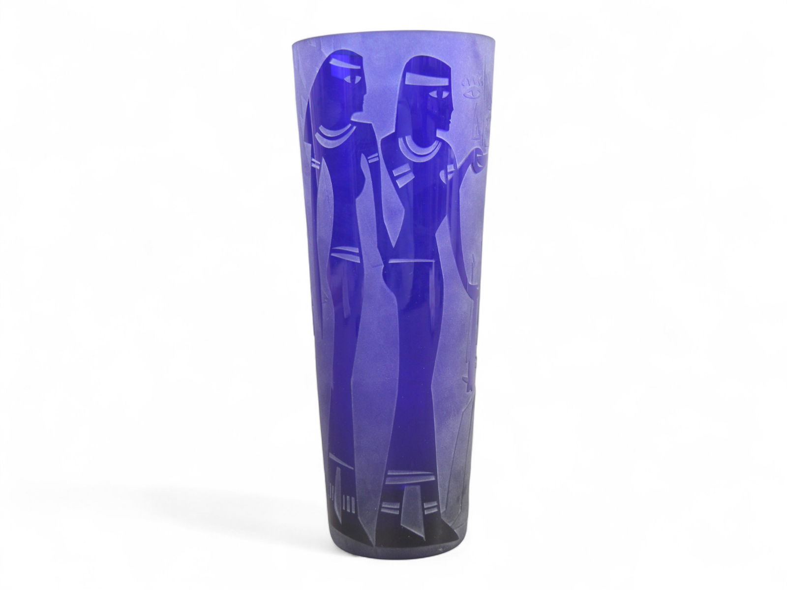 Cobalt Blue Art Glass Vase - Egyptian Style Motif: Tall cobalt blue art glass vase featuring etched Egyptian-style figures and hieroglyphic motifs in relief around the body. The design is deeply etched into the glass, creating a sculptural effect with