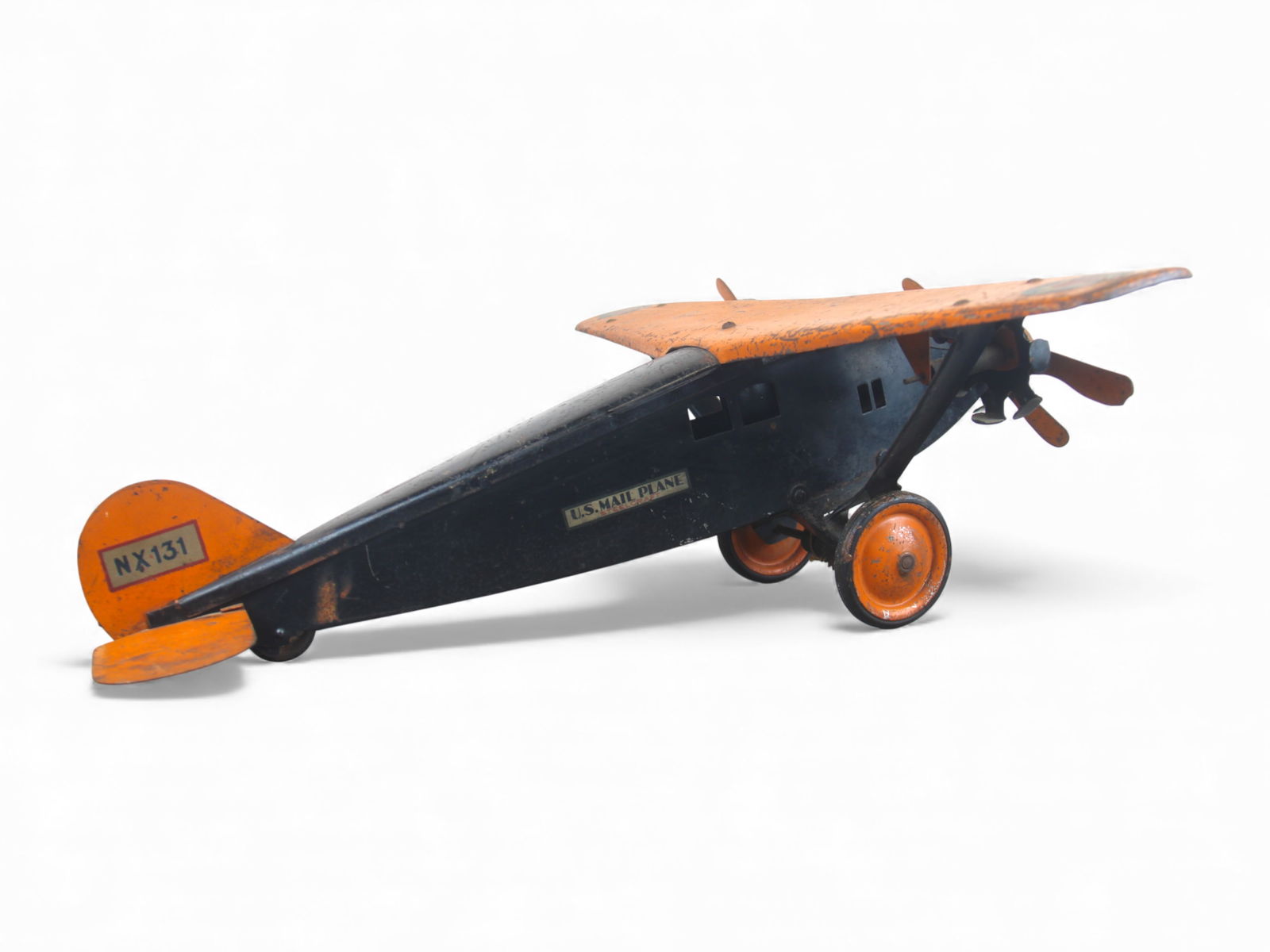 Steelcraft U.S. Mail NX131 Plane: Early Steelcraft U.S. Mail Plane in black and orange paint with original decals, including "U.S. Mail Plane" on the fuselage and U.S. roundel insignias on both wings. Tail wing has "NX 131" decal.