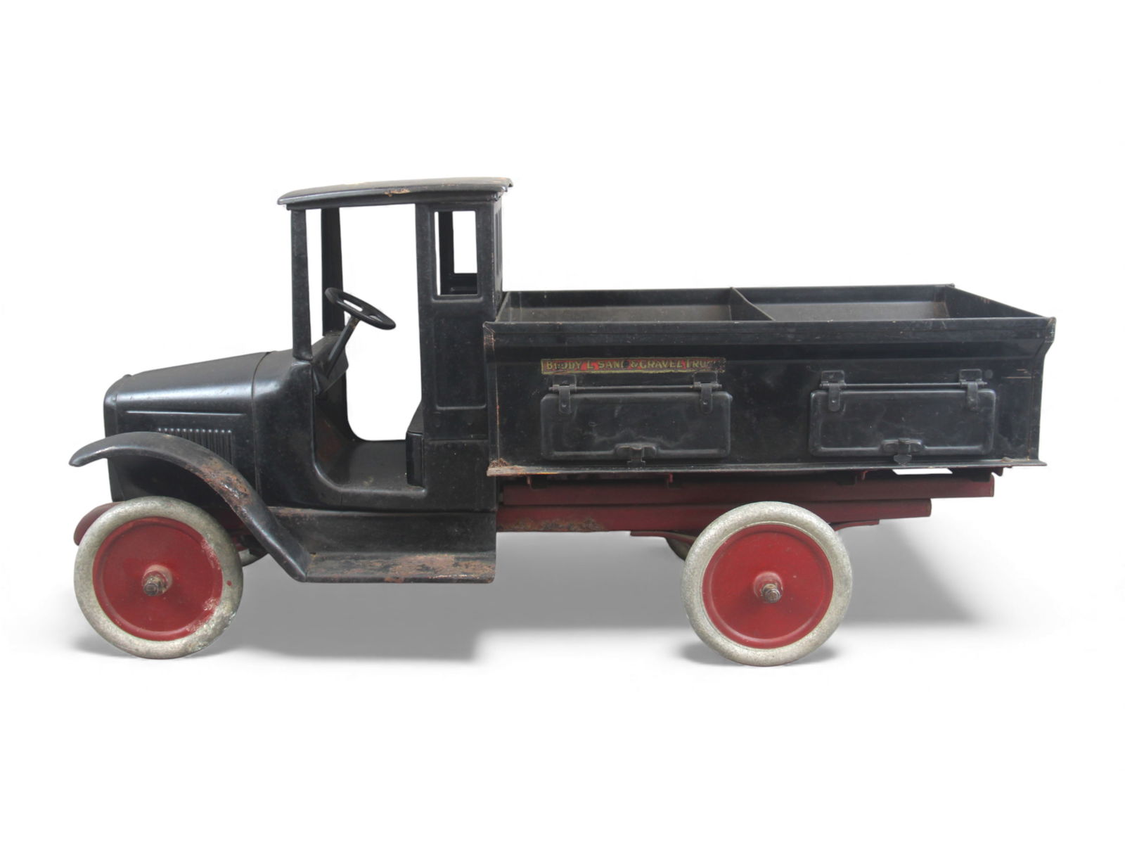Buddy L Sand & Gravel Truck w/Bed Divider: Buddy L pressed steel Sand & Gravel Truck with black cab and dual bin gravel bed featuring side tailgate lids. Retains original Buddy L decals on the cab floor, grille, and along the side panels of th