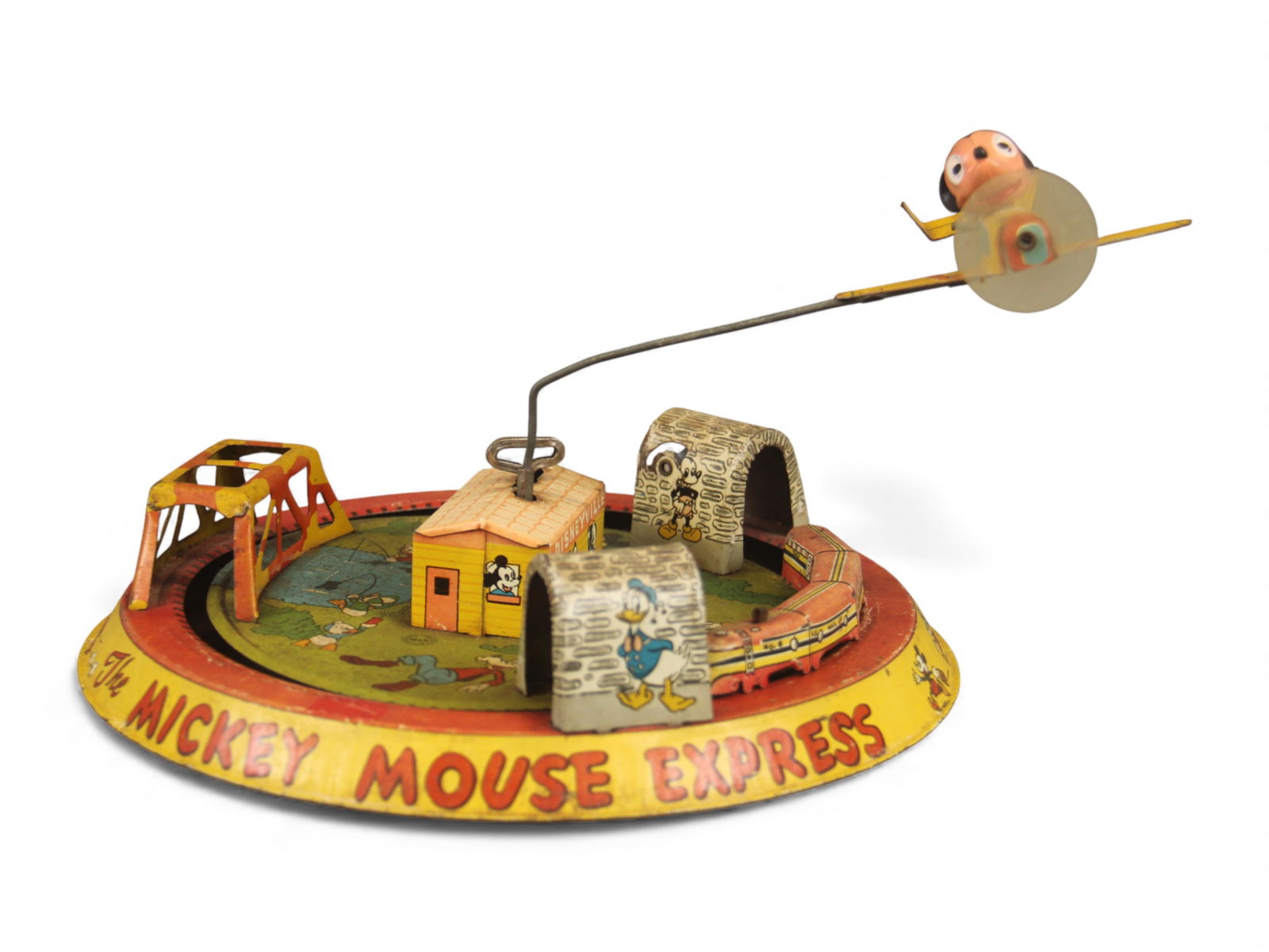 Marx Mickey Mouse Express Toy: Marx tin lithographed "Mickey Mouse Express" wind-up toy, all original. Features a train circling the base while a plane flies overhead. Measures approx. 9?" in diameter. Working when tested; shows
