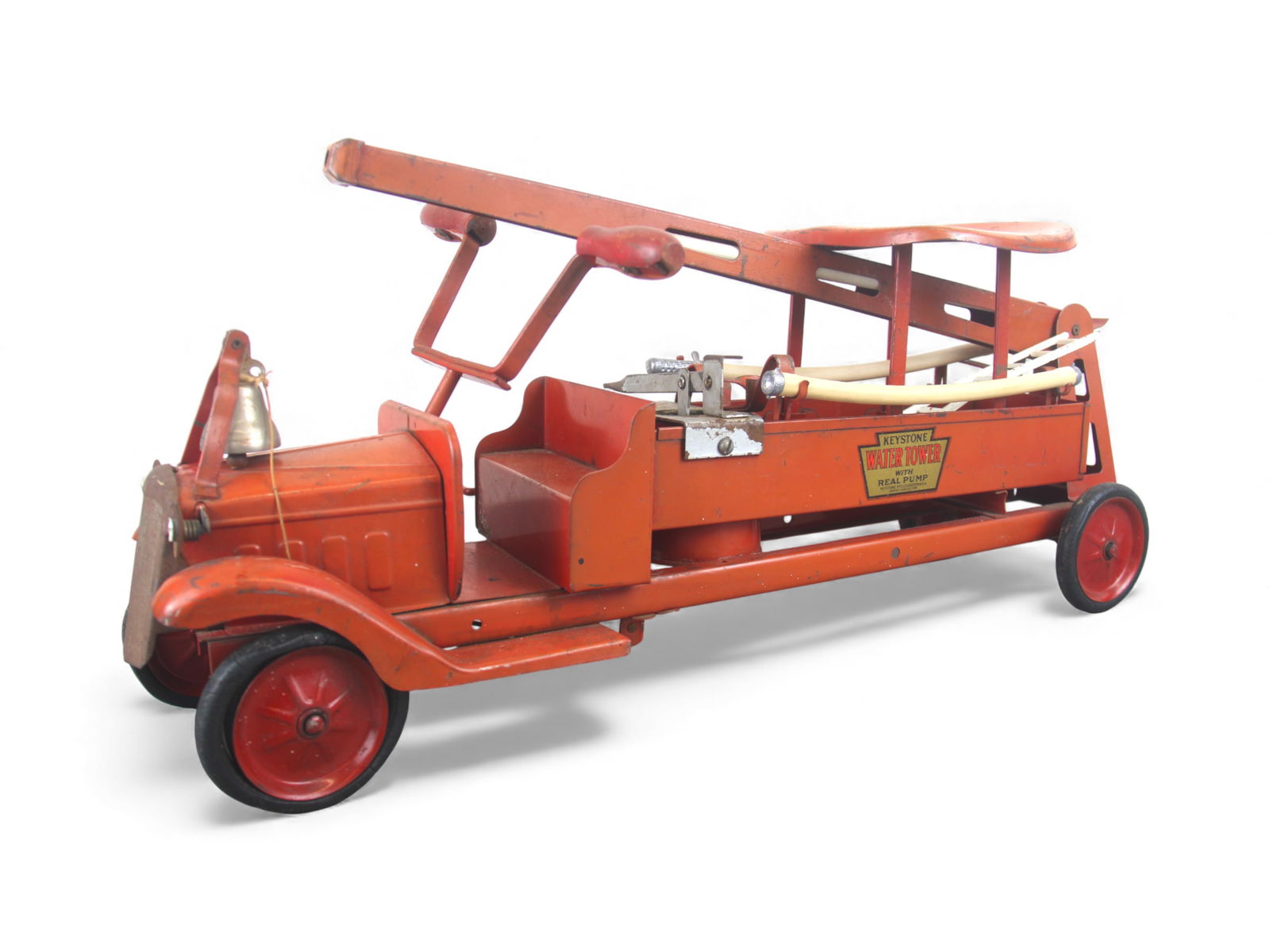 Keystone Ride-on Water Tower: 1930. Painted pressed steel with rubber wrapped steel spoked hubs, 26" long. It has its original seat and wood steering handles. The tower raises fine with replaced inner hose, but missing the cannon