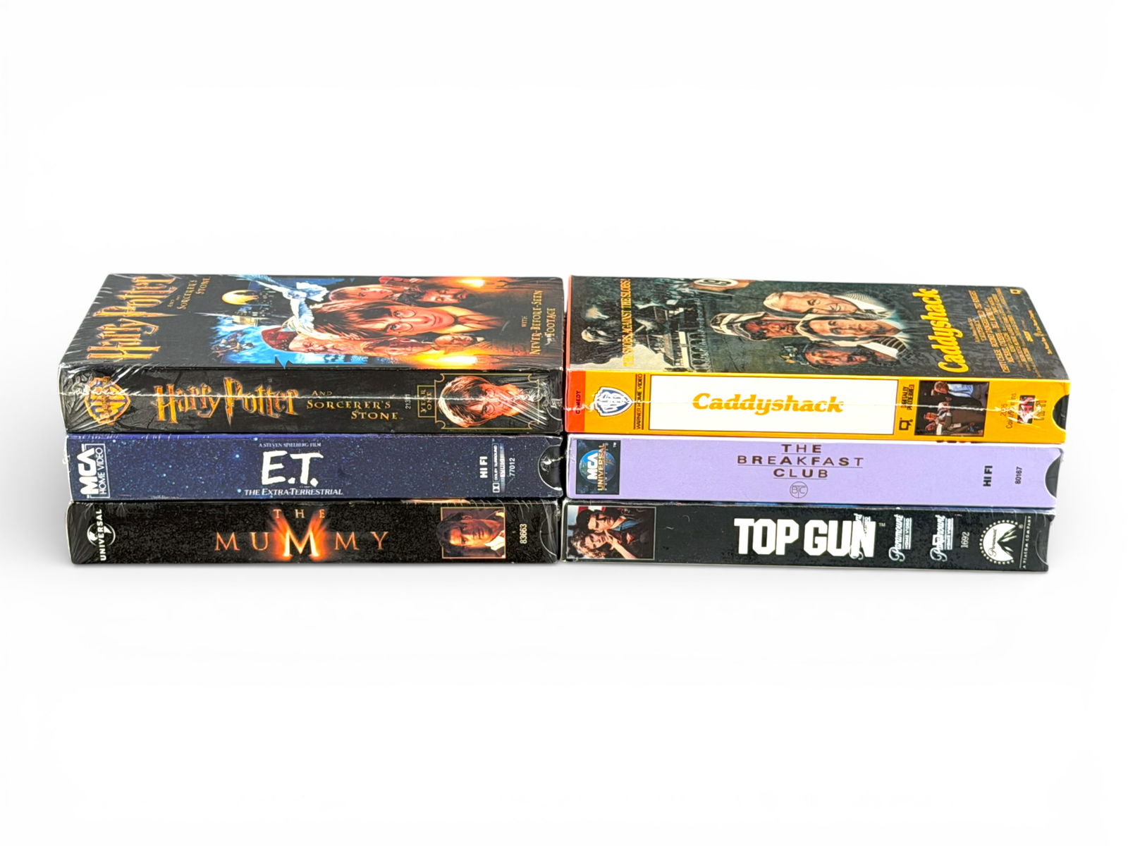 (6) Sealed VHS: Potter, E.T., Mummy, Caddyshack: Lot of six sealed VHS movies including Harry Potter and the Sorcerer's Stone, E.T. The Extra-Terrestrial, The Mummy, Caddyshack, The Breakfast Club, and Top Gun. All appear factory sealed in original