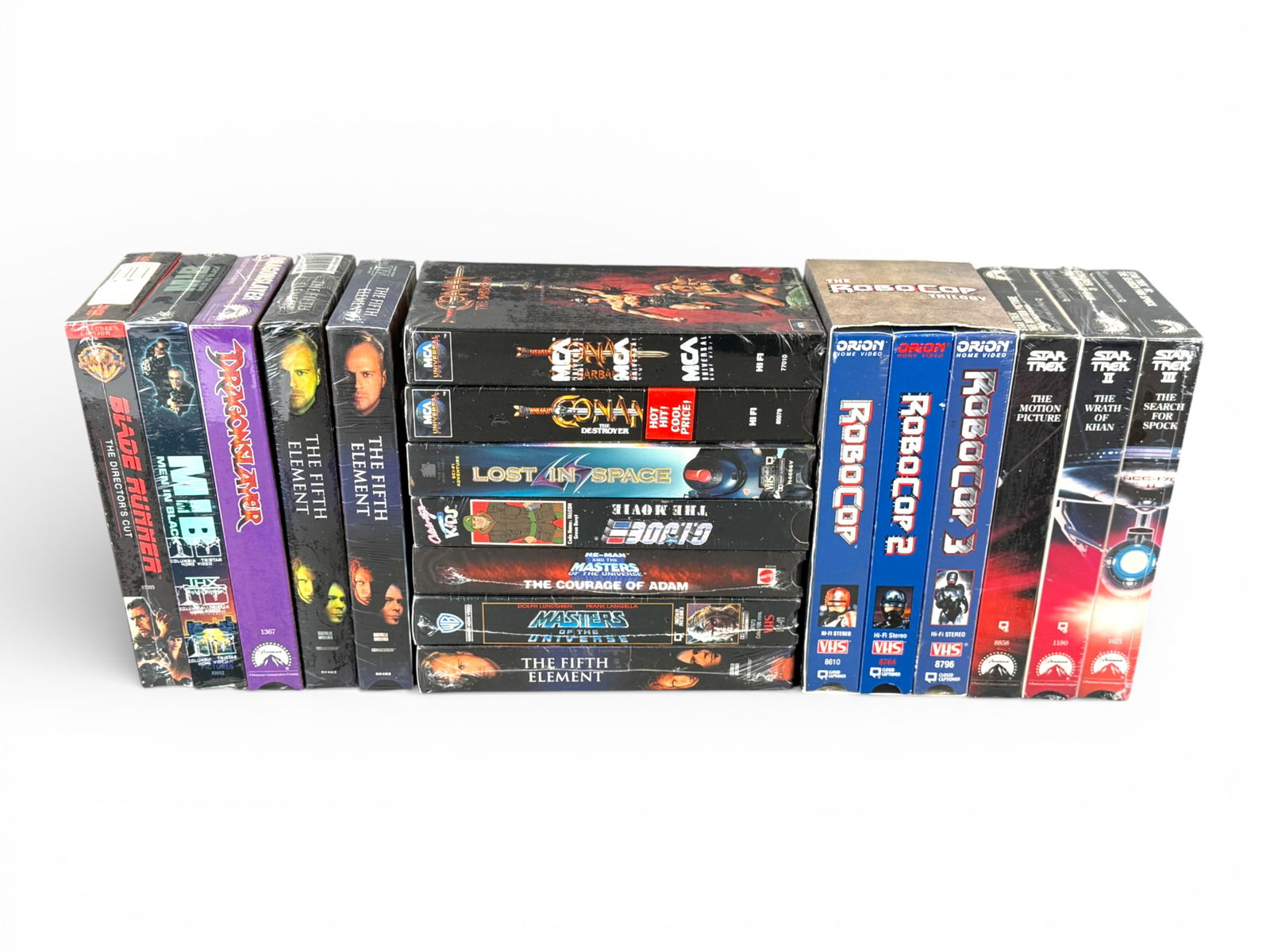 (18) Sealed VHS: Sci-Fi & Action Collection: Large lot of eighteen sealed VHS tapes including The Fifth Element (3), RoboCop Trilogy box set, Masters of the Universe, He-Man: The Courage of Adam, G.I. Joe: The Movie, Dragonslayer, Men in Black,