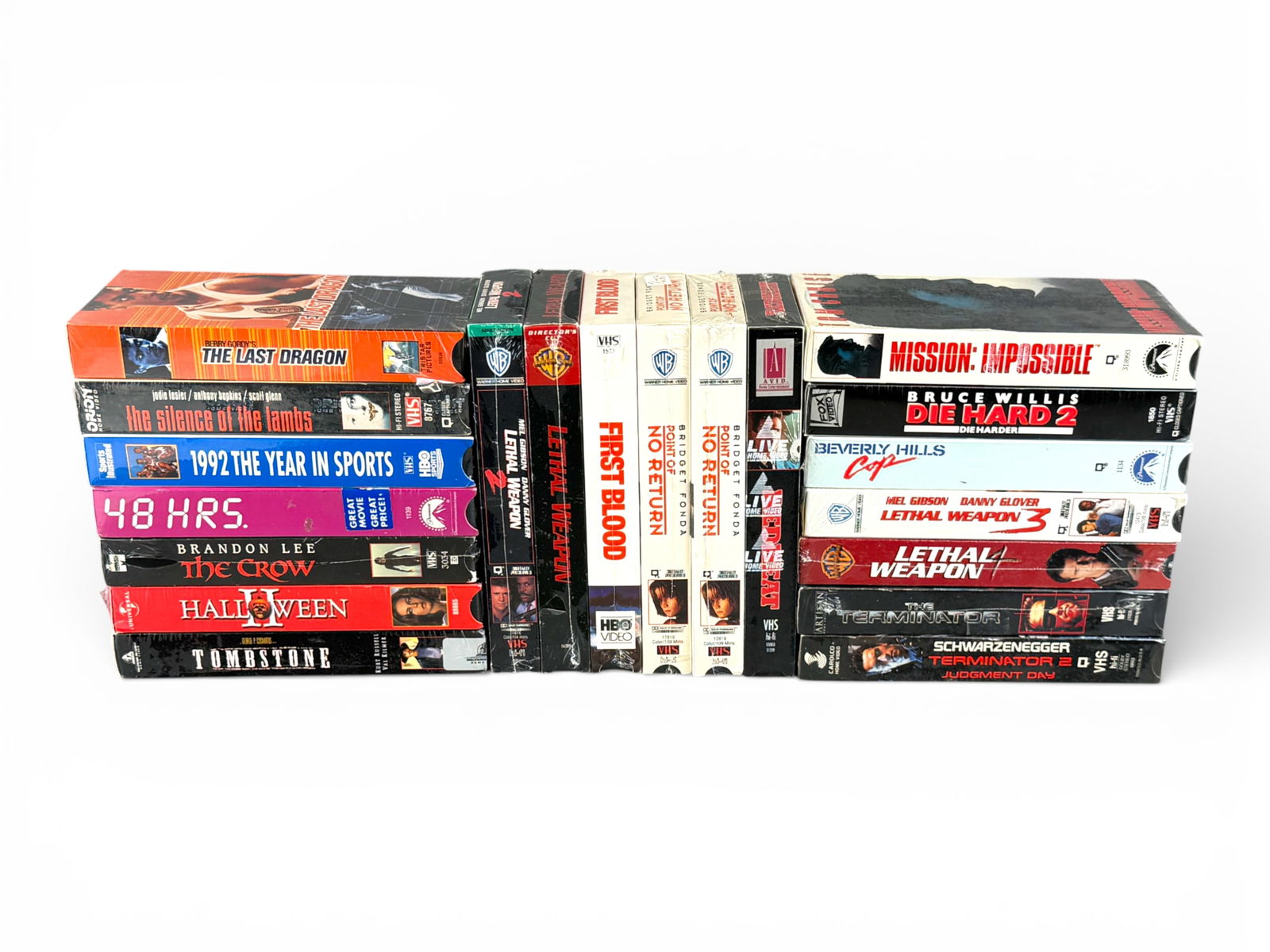 (20) Sealed VHS: Action & Thriller Collection: Large lot of twenty sealed VHS movies including Mission: Impossible, The Last Dragon, The Crow, Halloween, The Silence of the Lambs, Tombstone, 48 Hrs., 1992: The Year in Sports, Point of No Return