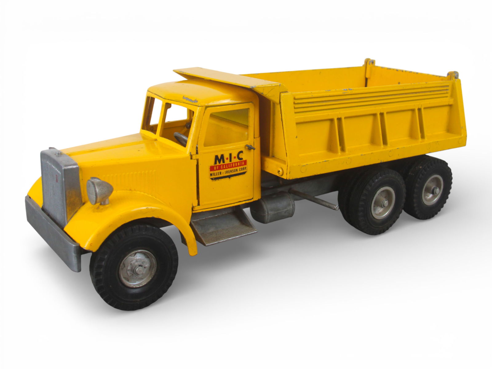 Smith-Miller B-Mack MIC Dump Truck: Painted die cast with rubber tires, 17" long. It has intact opening doors, functional steering, hydraulic dump still functions nicely and decals are 98%. It show light play wear. Shipping: Weiss Aucti