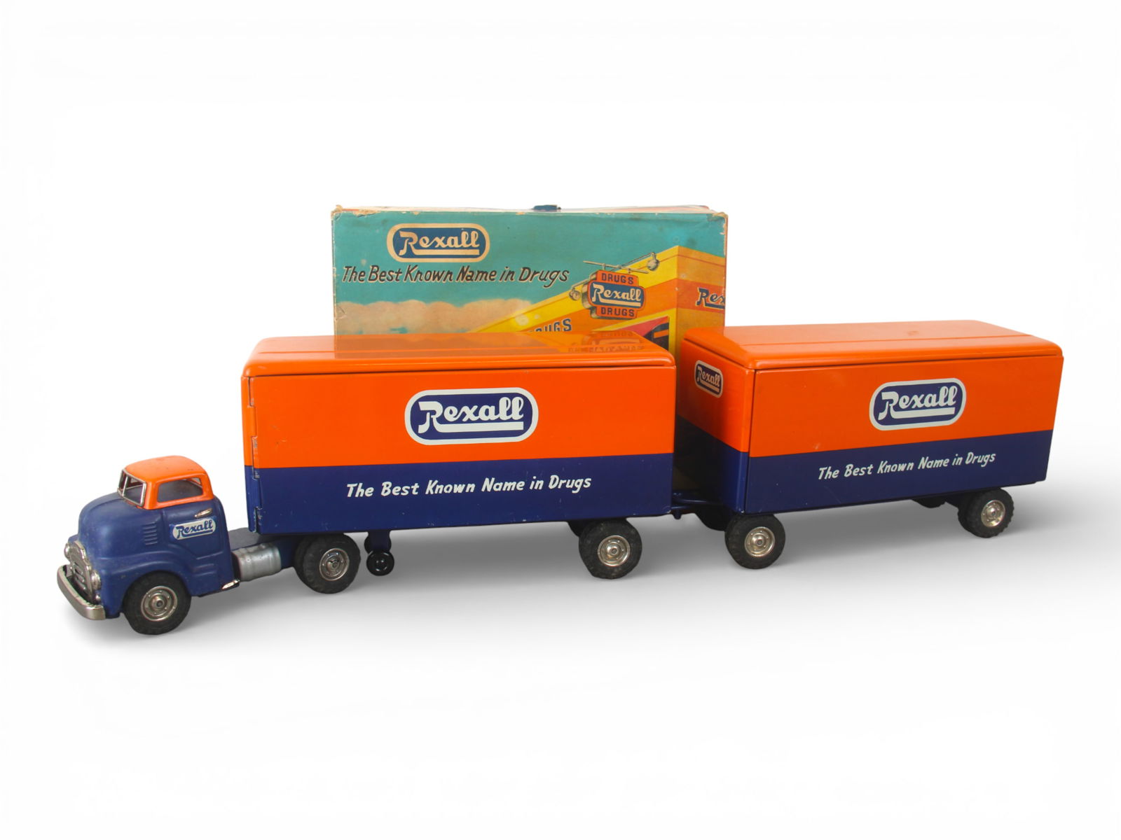 Boxed Fuji, Japan Rexall Tandem Truck: Litho tin, tractor, rubber tires with functional friction drive, matching trailer with Pup Tandem. Tractor needs a clean and polish, rest show very light wear with box, top has two corners split. Ship