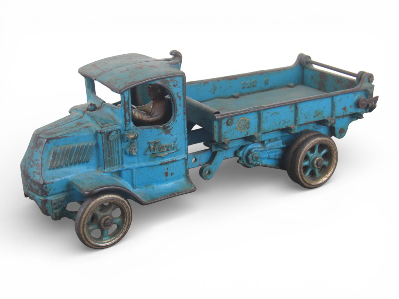 Arcade Cast Iron Mack Dump Truck: Painted cast iron Bullnose Mack with rubber wrapped cast iron tires, 12" long. It is missing the dump mechanism, but retains its driver and rear gate. It shows moderate play wear.From the Gary Slutzky