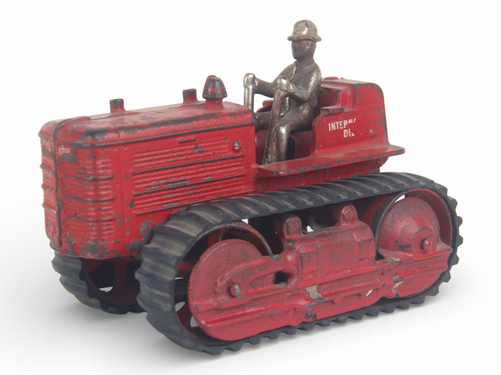 Arcade Cast Iron IHC Diesel Tractor: Painted cast iron with nickel plated driver, 7 1/2" long. It has replacement tracks and decals are 75%. It shows moderate play wear.From the Gary Slutzky Collection of Pressed Steel, Tin, and Cast Iro