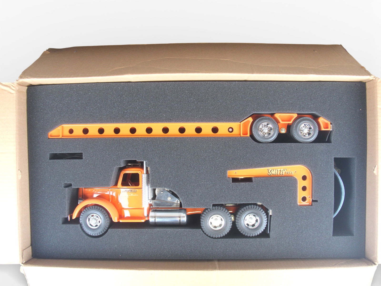 Thompson Smith-Miller Mack Low Boy: Beautiful modern truck in the Smith-Miller style, 34" long. Has front load style platform trailer and appears never removed from box.From the Gary Slutzky Collection of Pressed Steel, Tin, and Cast