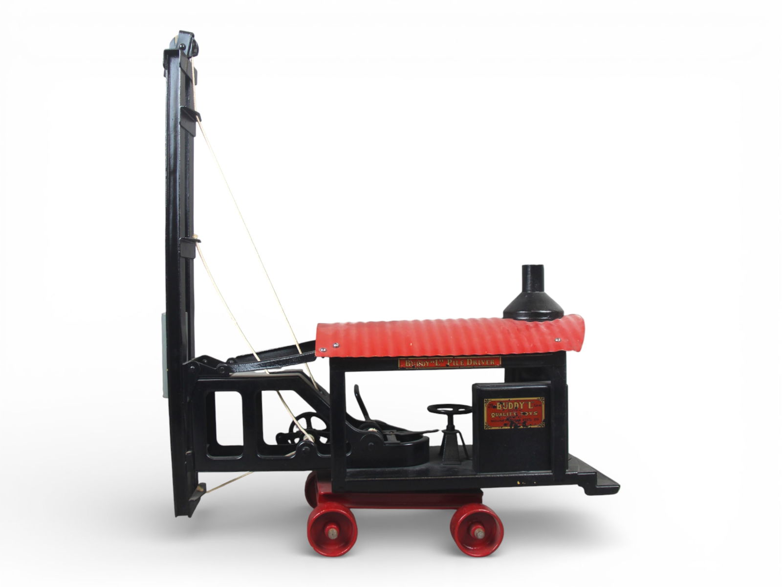 Restored Buddy L Pile Driver: Painted pressed steel, 20" long. Hobbyest level restoration with decals. Shows light play wear and would benefit from a cleaning.From the Gary Slutzky Collection of Pressed Steel, Tin, and Cast Iron