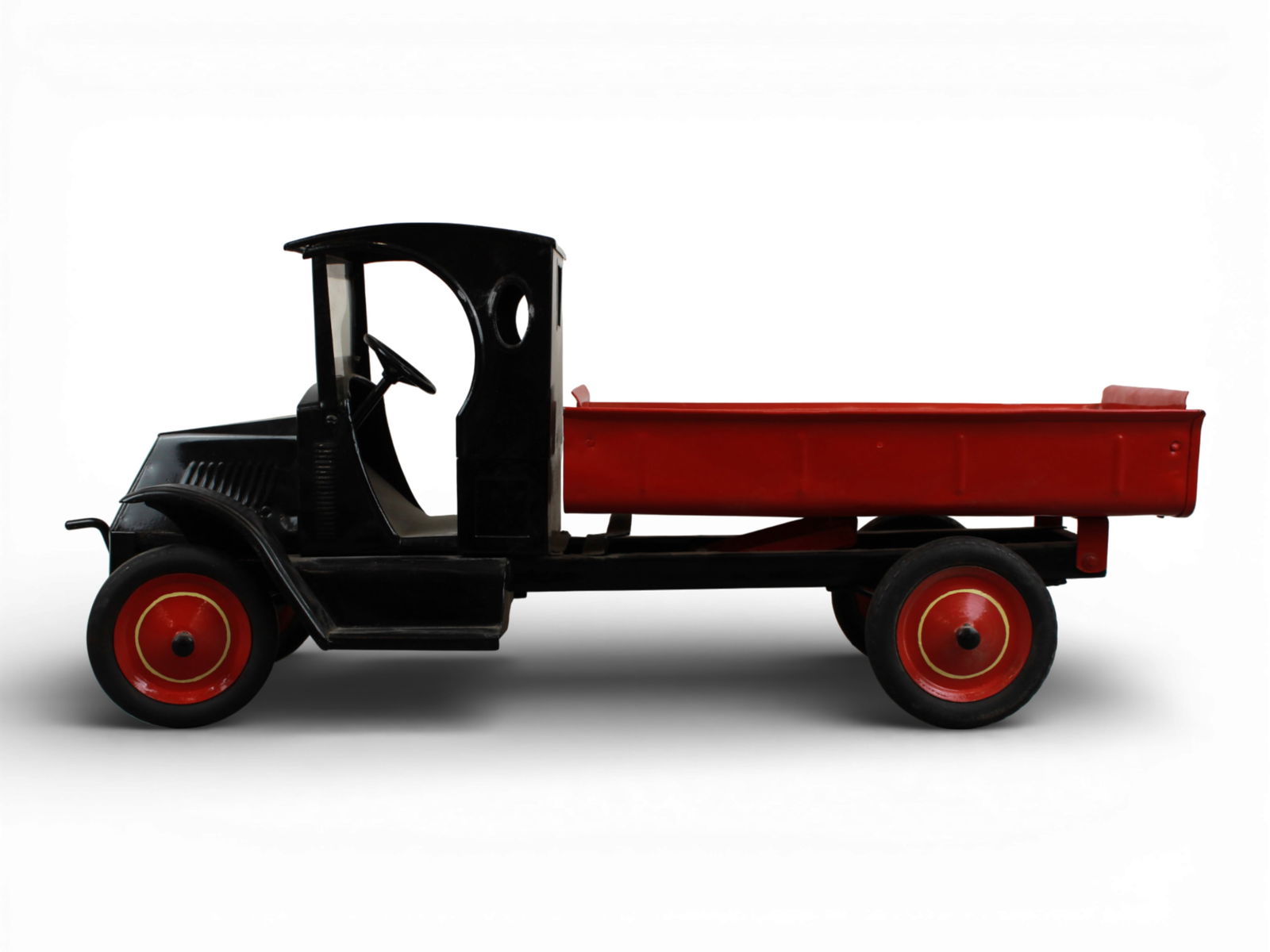 Restored Giant American National Dump Truck: Painted pressed steel with rubber wrapped tires over steel hubs, 26" long with Bulldog Mack front. It has a closed cab with front glass, steerable wheels, crank action dump back, using front crank.