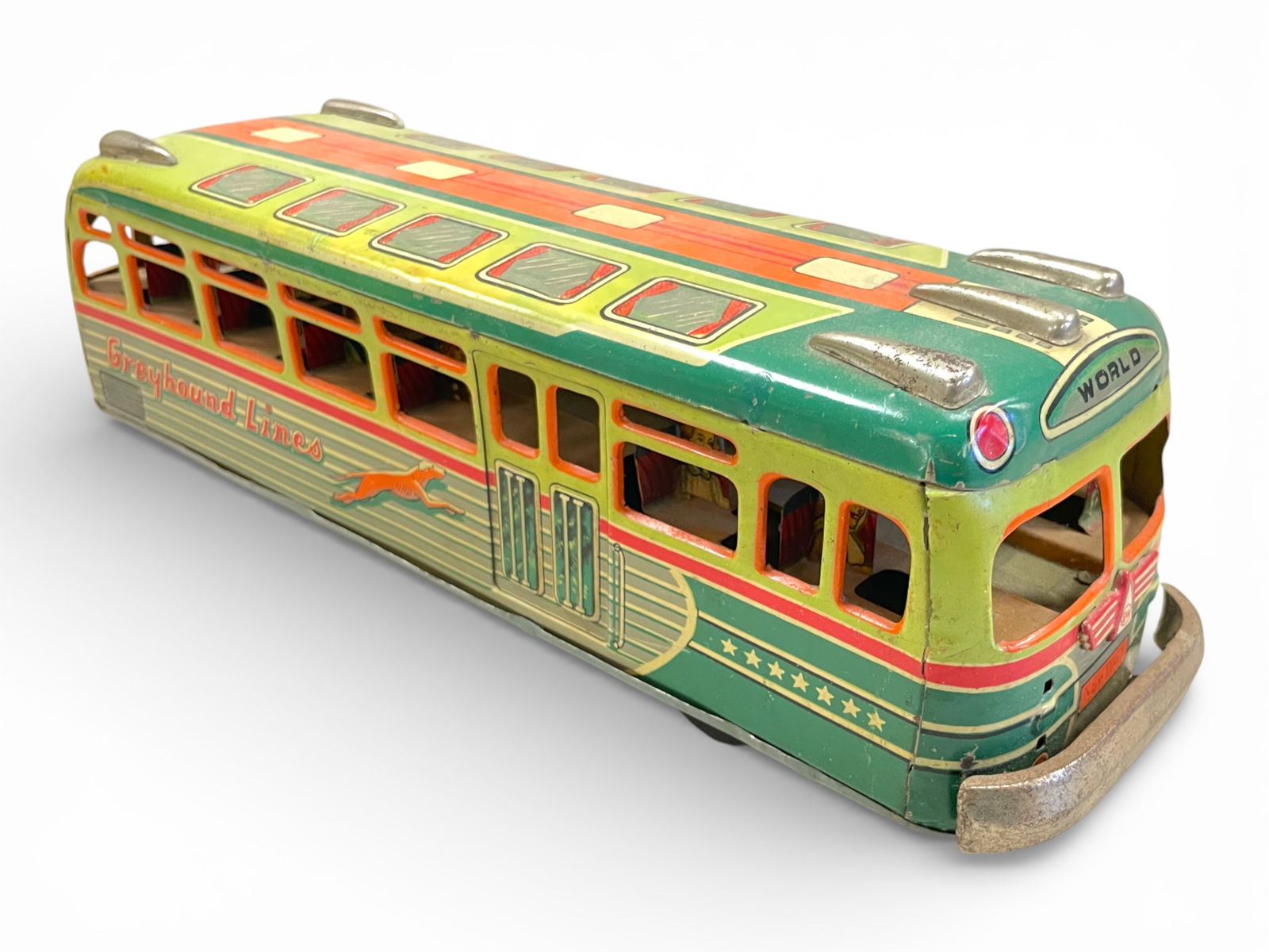 Early SAN Japan Greyhound Bus: Nice litho tin friction toy, 12" long. Features Nice cartoon lithos of passengers, with an African American in the back seat. Not an easy toy to find. It is fairly clean and shiny, with some wear to