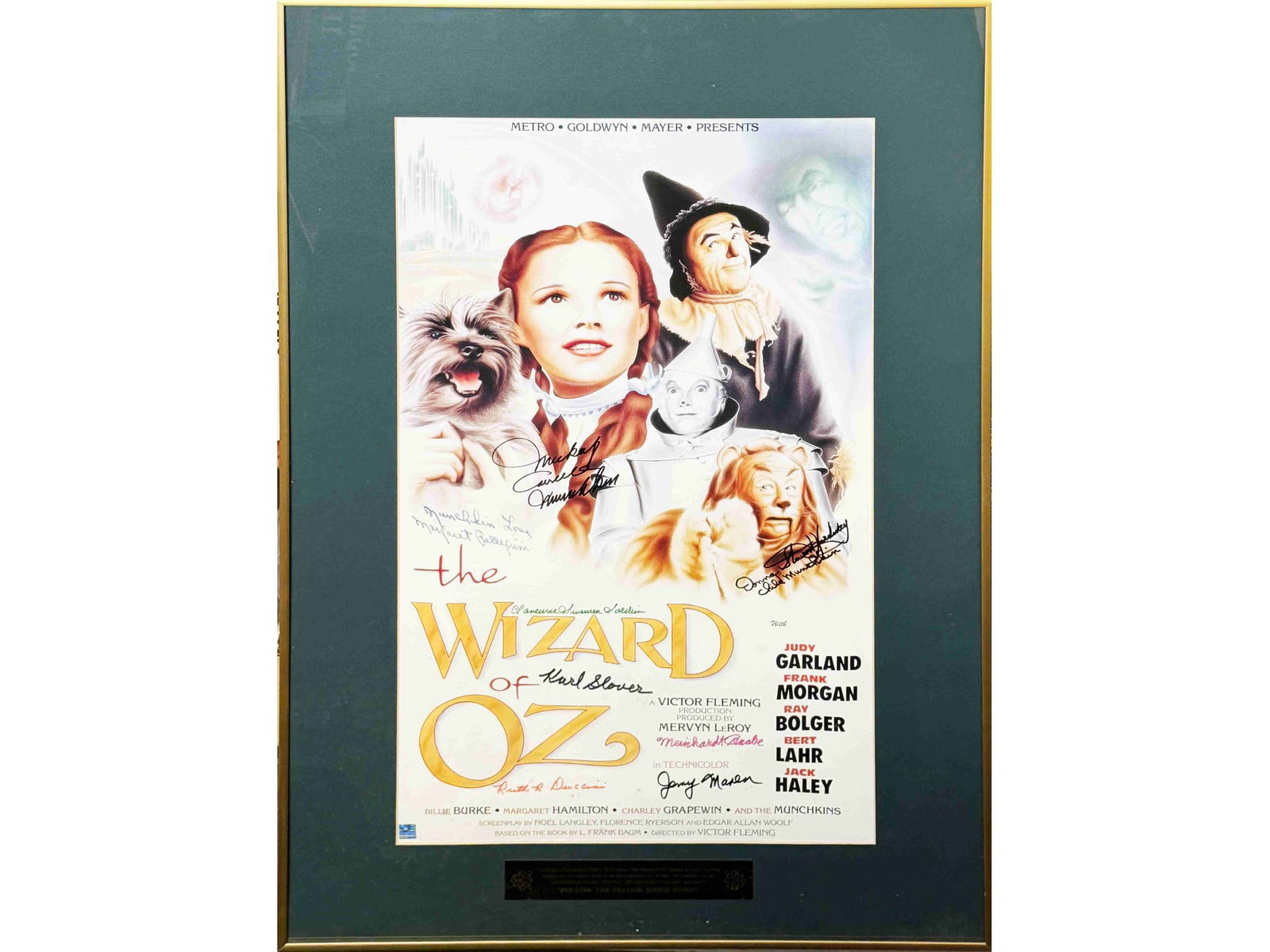 Wizard of Oz Munchkins Signed Poster: Color poster for The Wizard of Oz, measuring approximately 13.5" x 23" (21" x 30.5" framed), signed by multiple original Munchkin cast members who appeared in the classic 1939 film.Signatures include