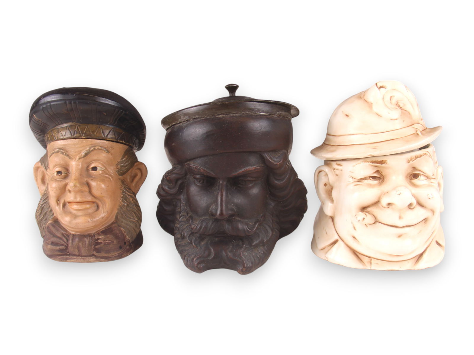(3) Figural Head Tobacco Jars: Includes Terra Cotta, Porcelain. Each 5 1/2"-6". See images for details. Shipping: Weiss Auctions offers full-service, in-house shipping for nearly all items in this auction. For a shipping quote, ple