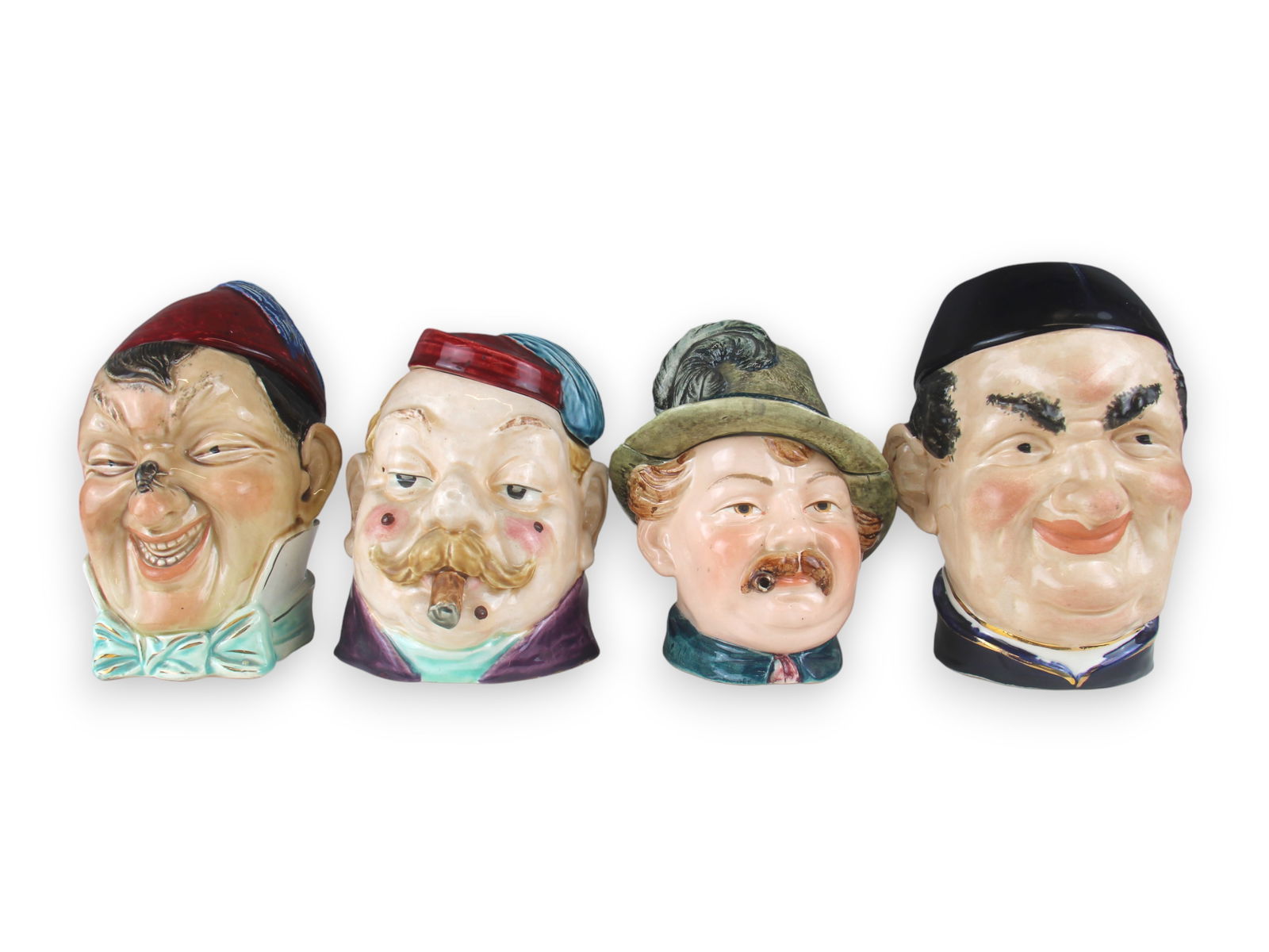 (4) Porcelain Glazed Figural Head Tobacco Jars: 6 1/2-7 1/2" tall each. Some wear. See images for details. Shipping: Weiss Auctions offers full-service, in-house shipping for nearly all items in this auction. For a shipping quote, please contact us