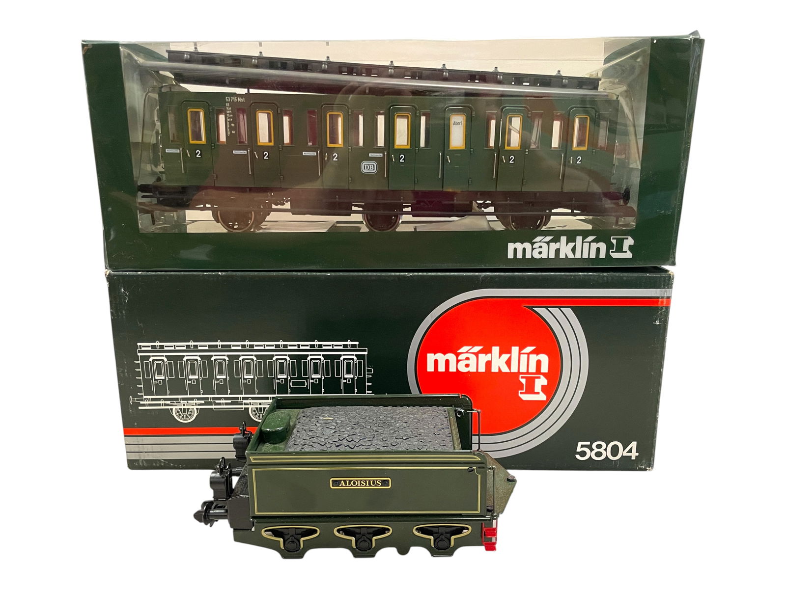 2pc Marklin Maxi Train Lot: 1/G Gauge. Includes a 5804 6-wheel Compartment coach, some clearstory windows are loose inside with decal sheet and paperwork; 5452 Aloiseus tender ONLY. Both show light use. Shipping: Weiss Auctions