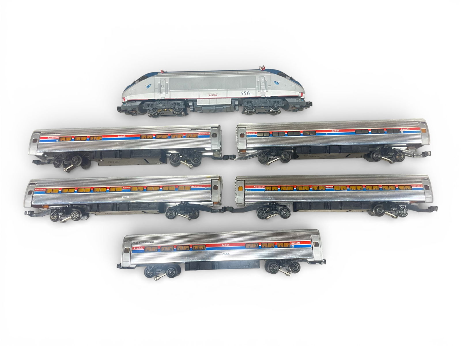 Mixed Mfg Amtrak Metroliner Set: Includes a Lionel 12323 Amtrak HHP-8 Electric with horn and bell, shows light to moderate play wear. 5 Elliot Wells Metroliner cars. 2 cars need a vestibule adjustment, all show light run time? From