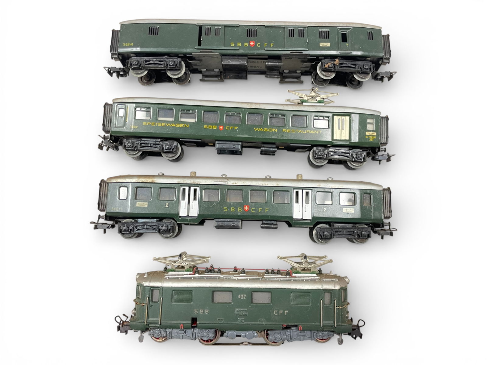 4pc 1950s Marklin HO Swiss Passenger Set: HO Gauge. Includes an RET800 electric, good castings; 348/1 Coach with opening doors; 348/2 Diner; 348/4 baggage. All would benefit from a light cleaning, but show very light play wear. Shipping: Weis