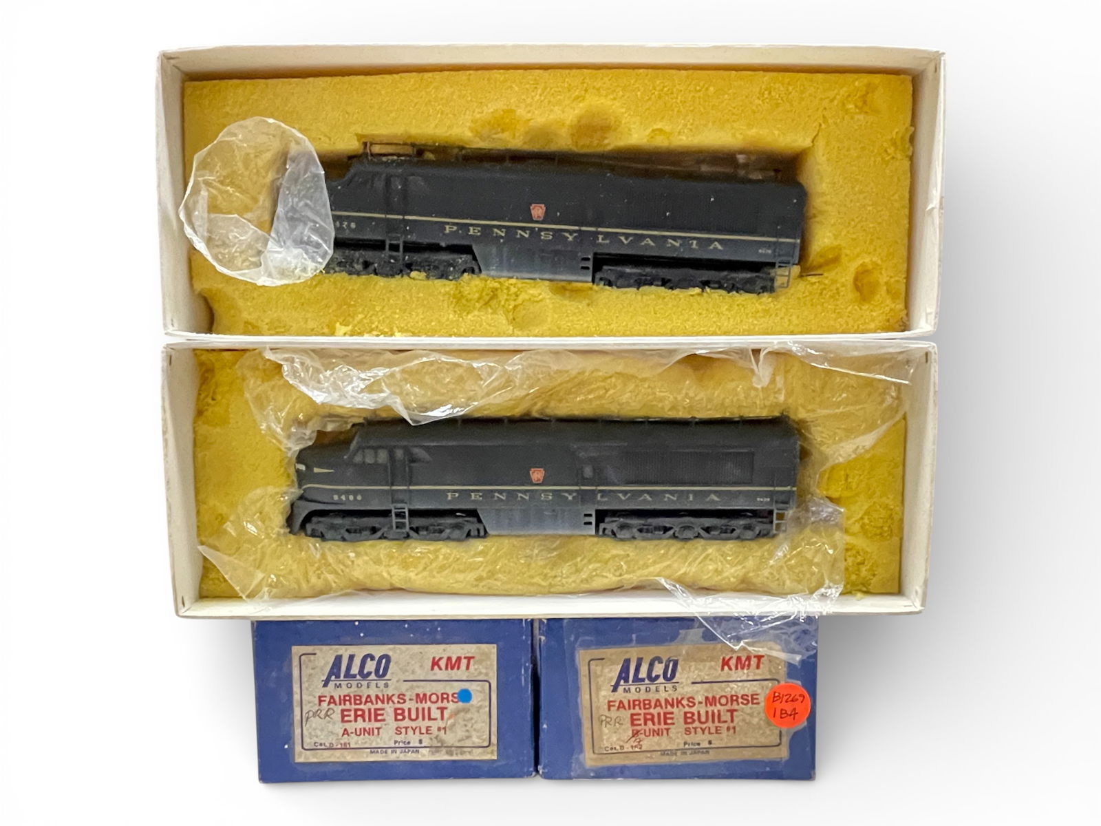 2 Alco Brass HO Erie Built FM A Units: HO Gauge. Both nicely custom painted one #9488 other #9476. Both are powered with open frame motors, antennas and window glass installed. They show light use with boxes, foam a bit hard.Shipping: