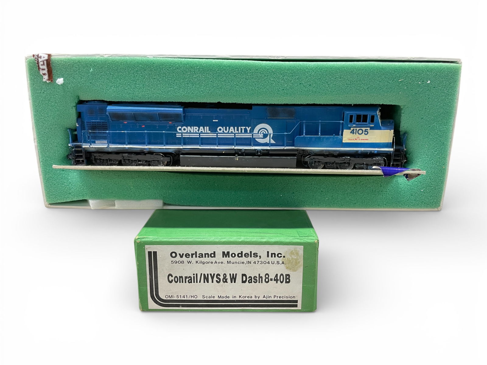 Overland Brass HO Conrail/NYS&W Dash8-40B: HO Gauge. Nice diesel with can motor, inside cab details #4105. It is custom painted, at hobbyist level and shows light use with box.Shipping: Weiss Auctions offers full-service, in-house shipping