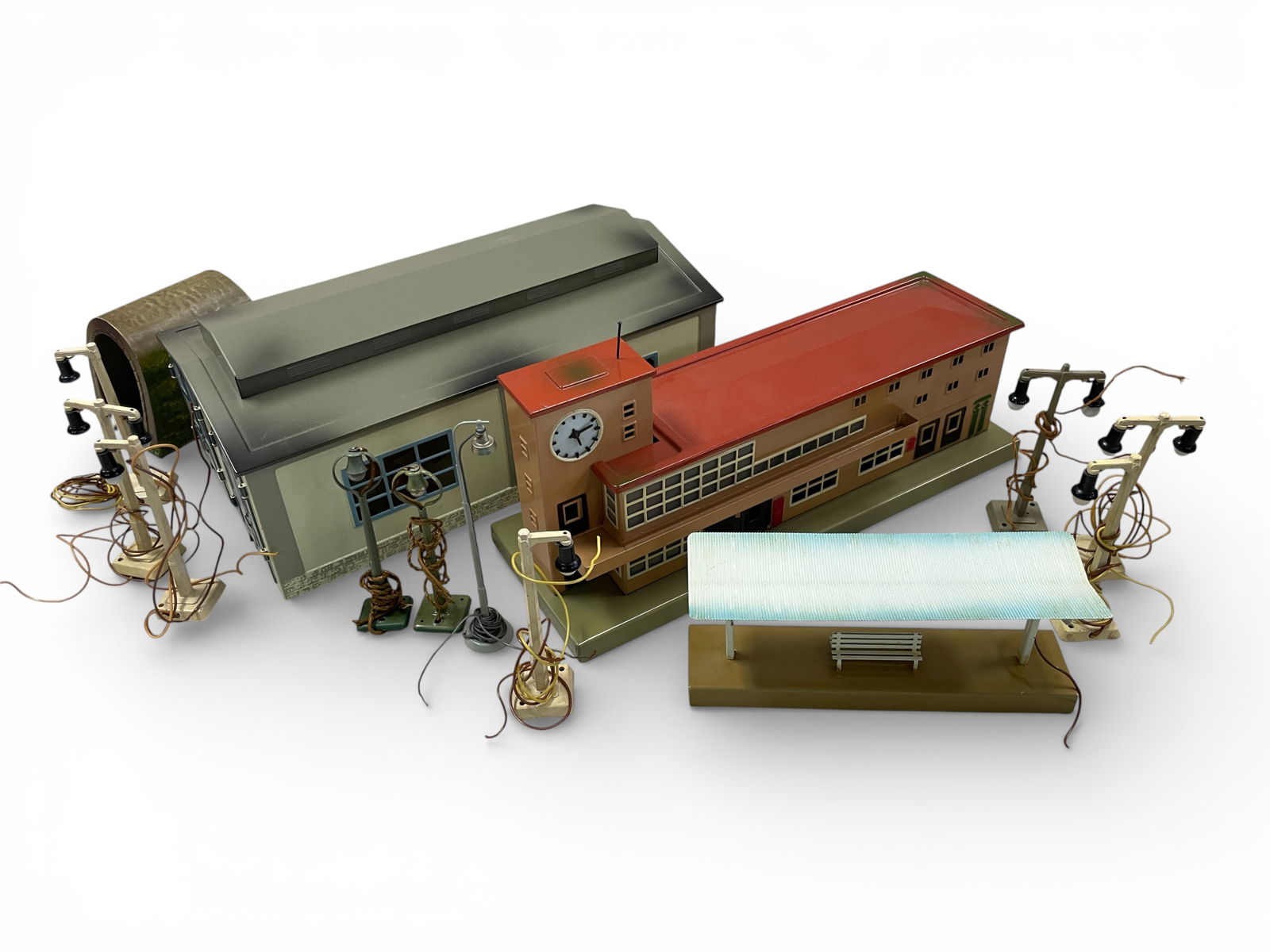 14 Nice Vintage Marklin HO Accessories: HO Gauge. Includes a 7029 2-stall engine shed; 418 2-Store Station with clock tower; small tin tunnel; 422 Station Platform; 3-448/1 Lampposts; 3-448/2 Lampposts; 2-447 arch lampposts; 7284 Station