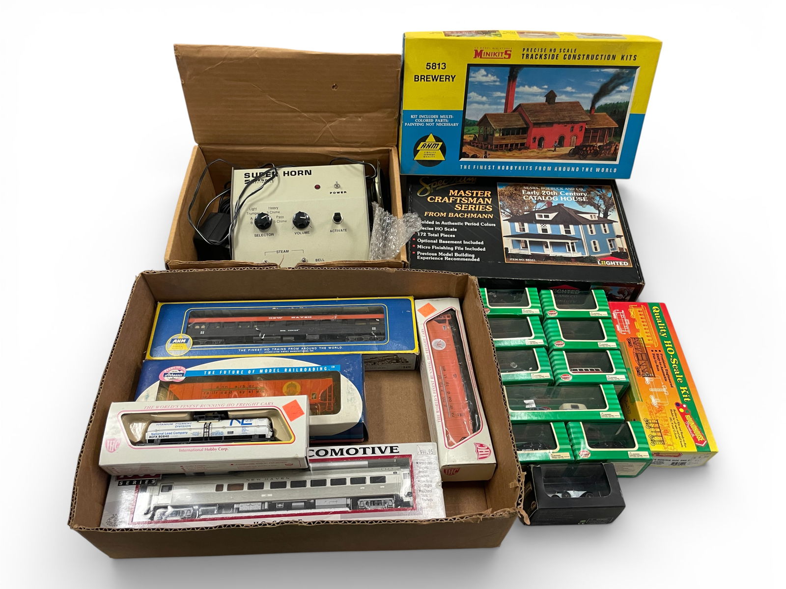 Assorted HO Cars & Accessories: HO Gauge. Includes a Proto 1000 Budd Diesel; several assorted rolling stock; several Model Power Scale Vehicles in boxes, Roanoke Super Horn Mechanism in box with parts; Spectrum Lighted House and Bre